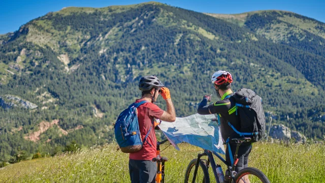 two men on mountain bikes with a map deciding where they are going